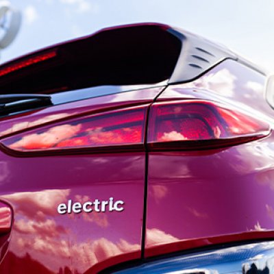A photo of the back of a red car, with the word 'electric' on the bodywork.