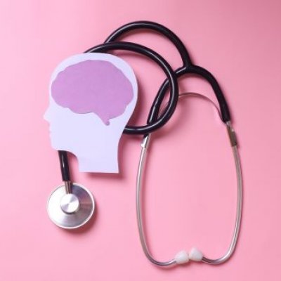 Stethoscope and stylised human head and brain on pink background.