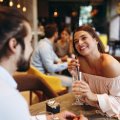 A man and a woman on a date, the woman holding a drink