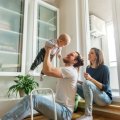 Young parents with dad holding toddler in air