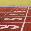Red running track with white lines and number painted on.