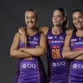 3 Firebirds players dressed in their purple netball uniforms smiling.