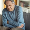 Man holding his lower abdomen in pain