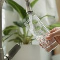 Person filling glass with water from tap. Adobe