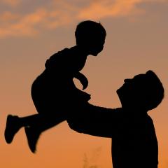 Silhouette of father and son playing