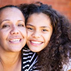 Mother and daughter posing smiling together