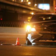 An impacted car with its hazard lights flashing