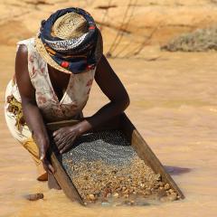 A Malagasy woman sieving for sapphires in a river