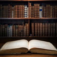 An open book lays on a table in a library