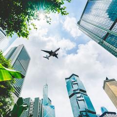 An airplane flying above city buildings