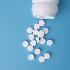 Medical tablets pouring out of a pill bottle