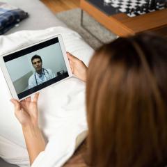 Woman talking to her GP on a tablet