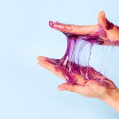 A sticky purple substance between someone's hands.