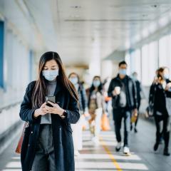 People walk through a hallway with face masks on