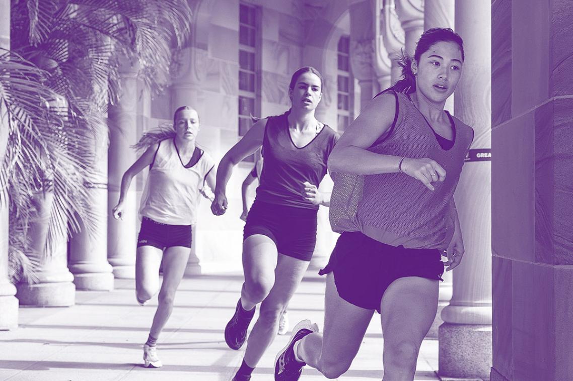 A group of women running through a sandstone hallway