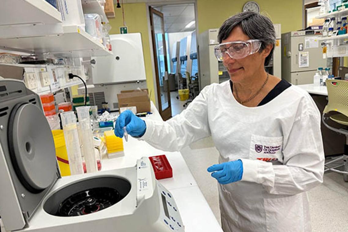 A female scientist holding a pipette near a machine