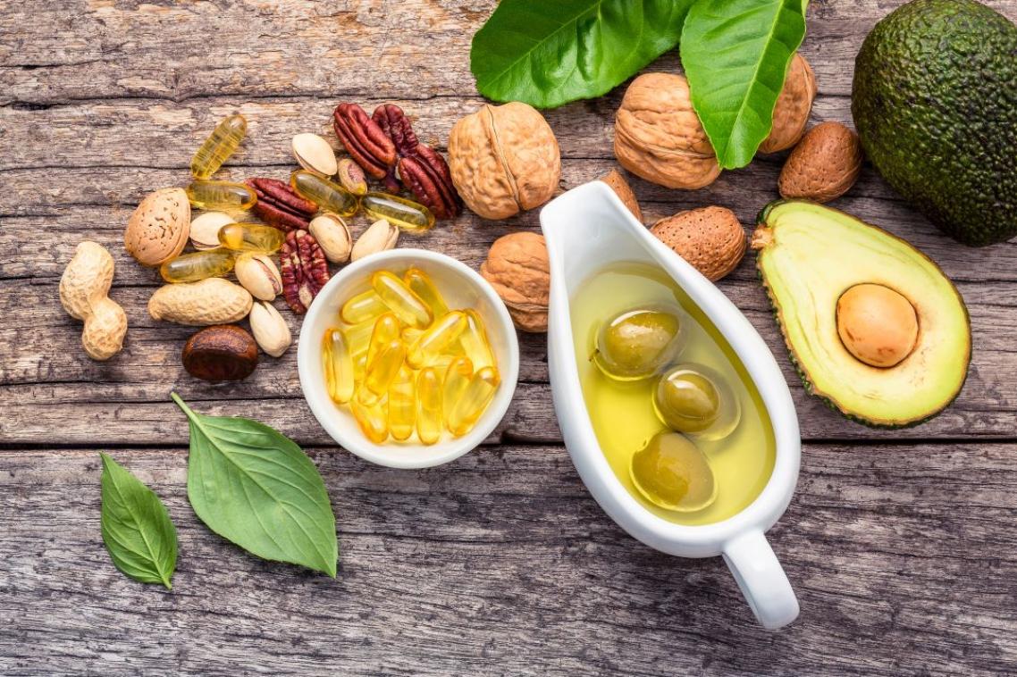 Avocado, nuts, olives sitting on a wooden table 