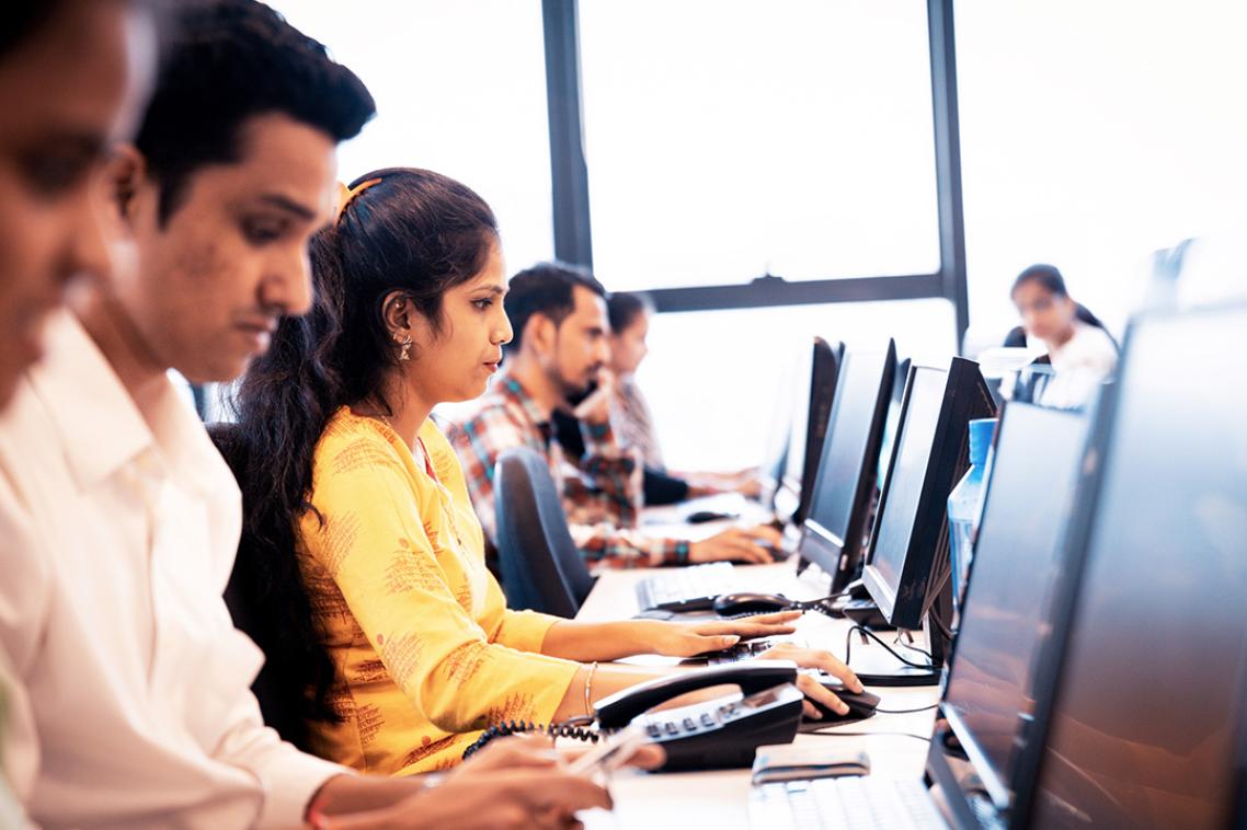 A group of women sitting in an office looking at computer screens