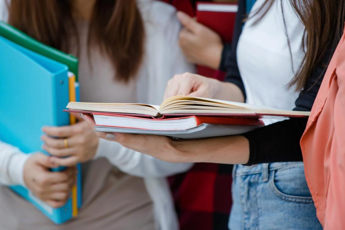 Female university students holding books.